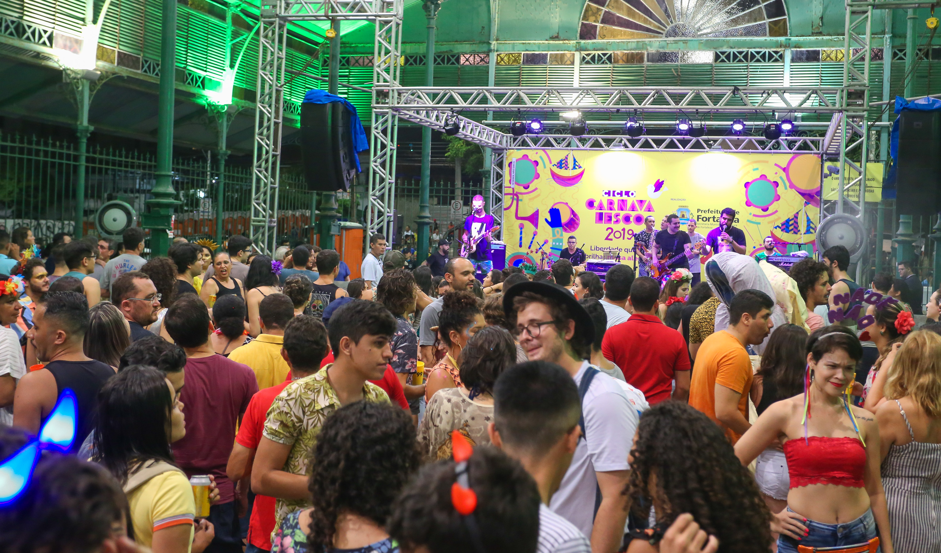foto mostra o interior do mercado dos pinhões com várias pessoas dançando